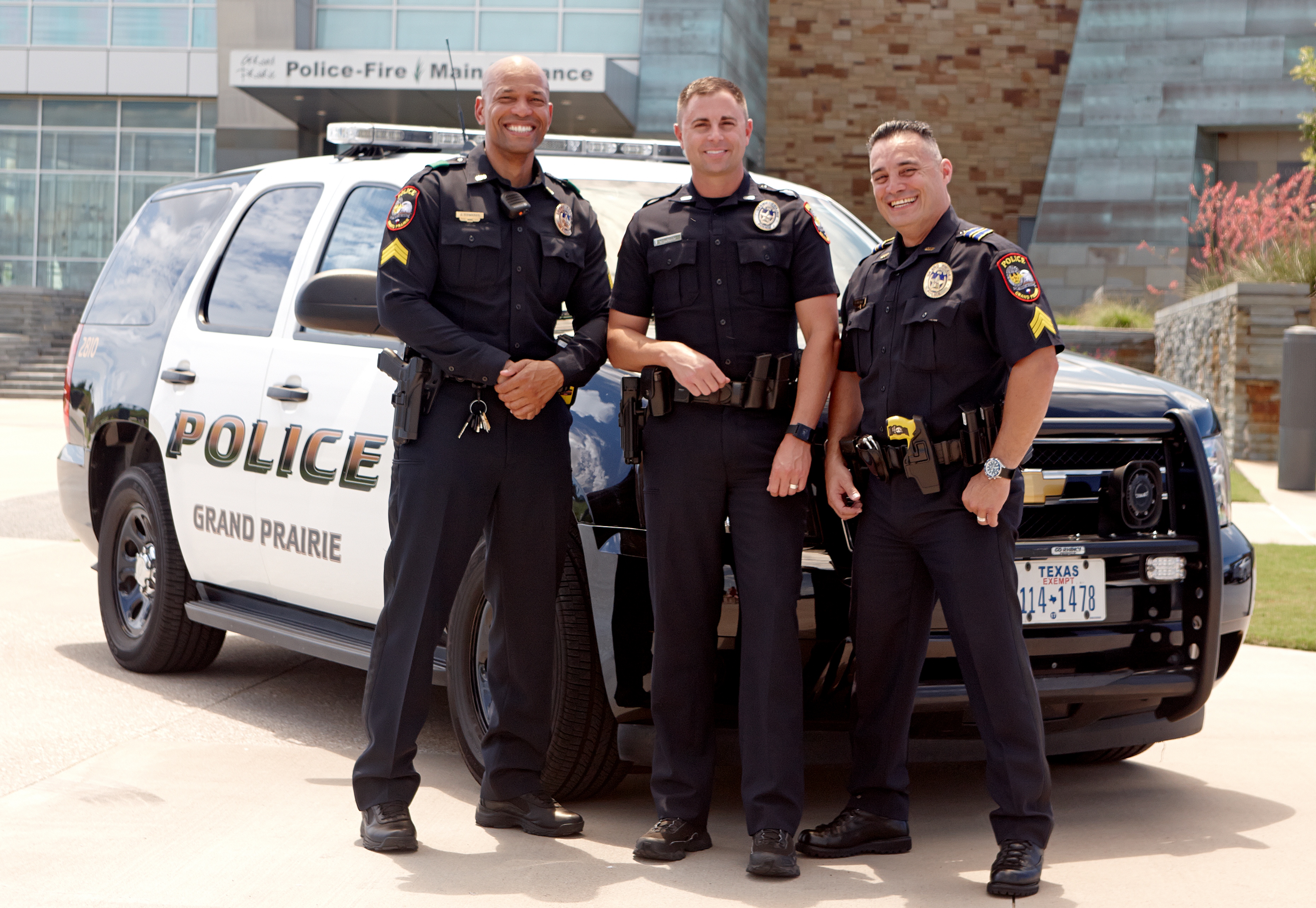 Officers posing in front of police car